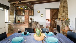 A dining area with a brick fireplace, stone walls, and a rustic wooden ceiling. - Lovely home in Torrox with private swimming pool, can be inside or outside (Torrox)