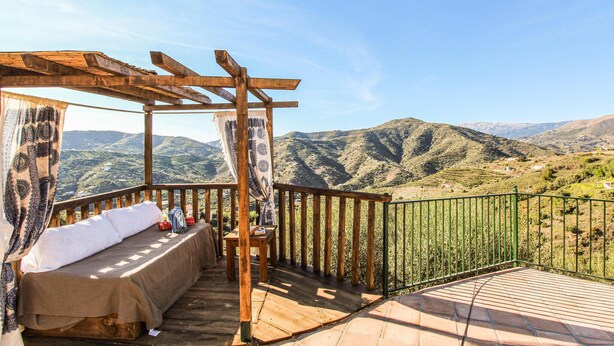 A wooden pergola with a bed and a table, overlooking a mountainous landscape. - Lovely home in Torrox with private swimming pool, can be inside or outside (Torrox)