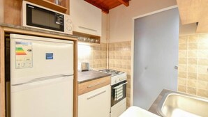 Una cocina compacta equipada con refrigerador, microondas, estufa y lavaplatos.