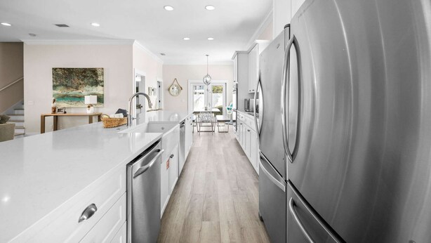 A modern kitchen with stainless steel appliances, a white countertop, and a wooden floor. - Gulf View - 30A Private Heated Pool, 3 min walk to the beach. No roads to cross. (Santa Rosa Beach)