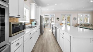 A modern kitchen with white cabinetry, stainless steel appliances, and a large island. - Gulf View - 30A Private Heated Pool, 3 min walk to the beach. No roads to cross. (Santa Rosa Beach)