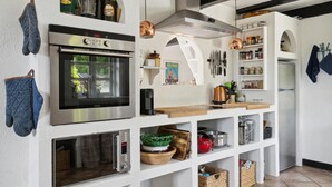 Uma cozinha moderna com forno embutido, cafeteira e diversos utensílios de cozinha.