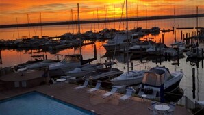 A marina with boats docked, a swimming pool, and lounge chairs. - Waterfront Setting w/ Top-Floor Views Overlooking Lake Charlevoix (Charlevoix)