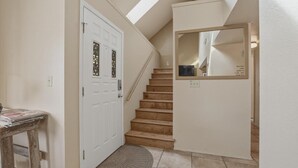 Un escalier avec une porte blanche et un miroir accroché au mur.