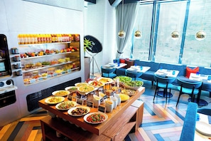 A buffet with various dishes, a coffee machine, and seating areas with tables and chairs. - Aloft by Marriott Tokyo Ginza (Tokyo)