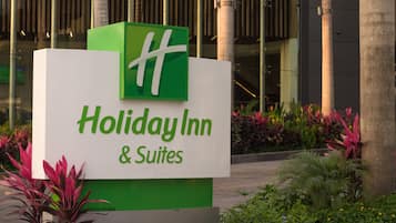 Señal de Holiday Inn & Suites, con logotipo verde y fondo blanco.