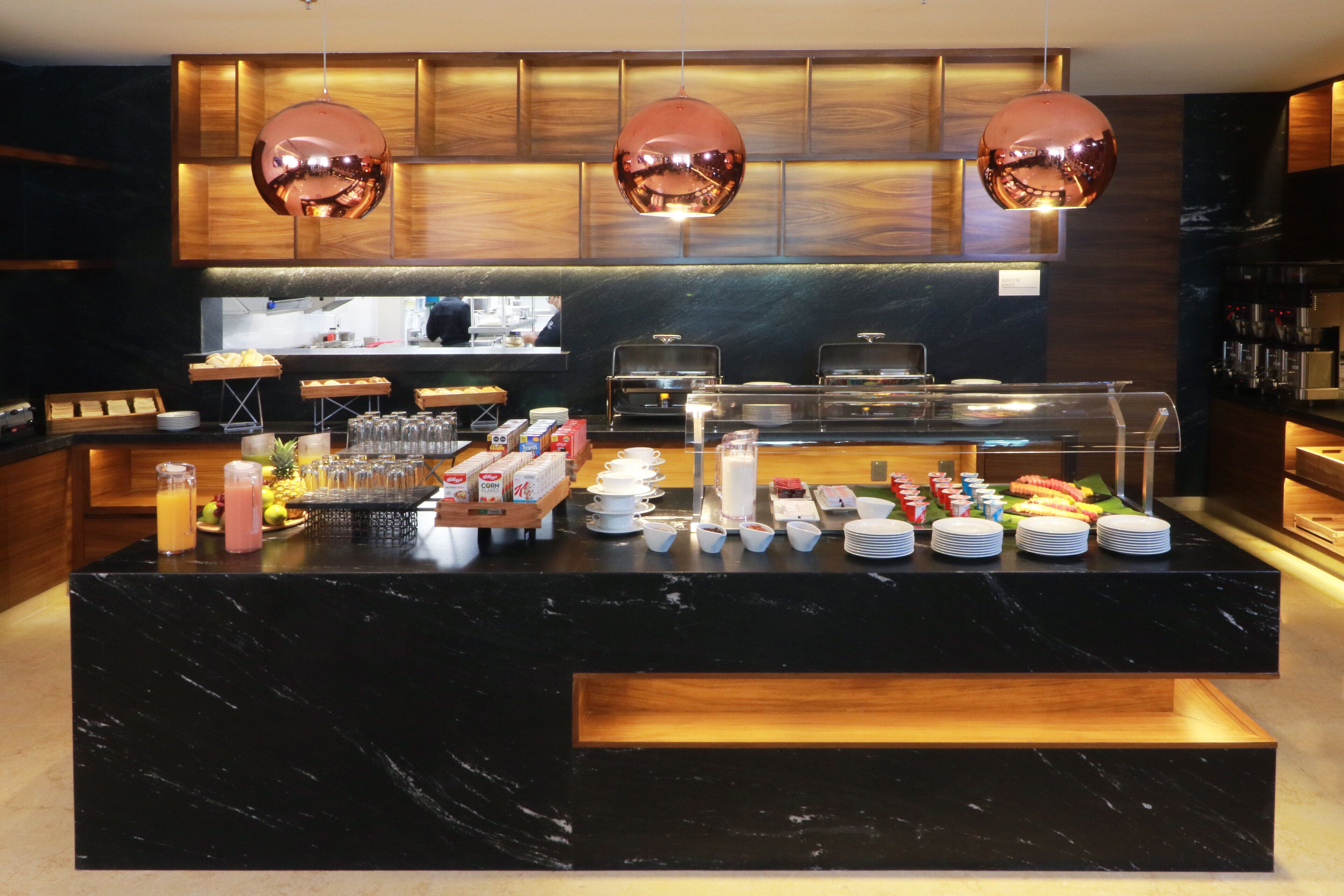A buffet setup with various food items, glassware, and a coffee station.