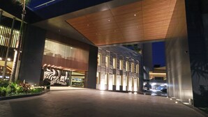A modern building with a large entrance, a wooden ceiling, and a mural on the wall.