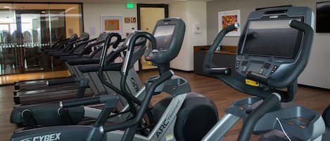 A gym with multiple stationary bikes and treadmills.