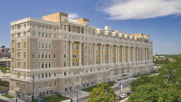Un edificio grande de varios pisos con un estilo arquitectónico clásico, con ventanas y columnas simétricas.