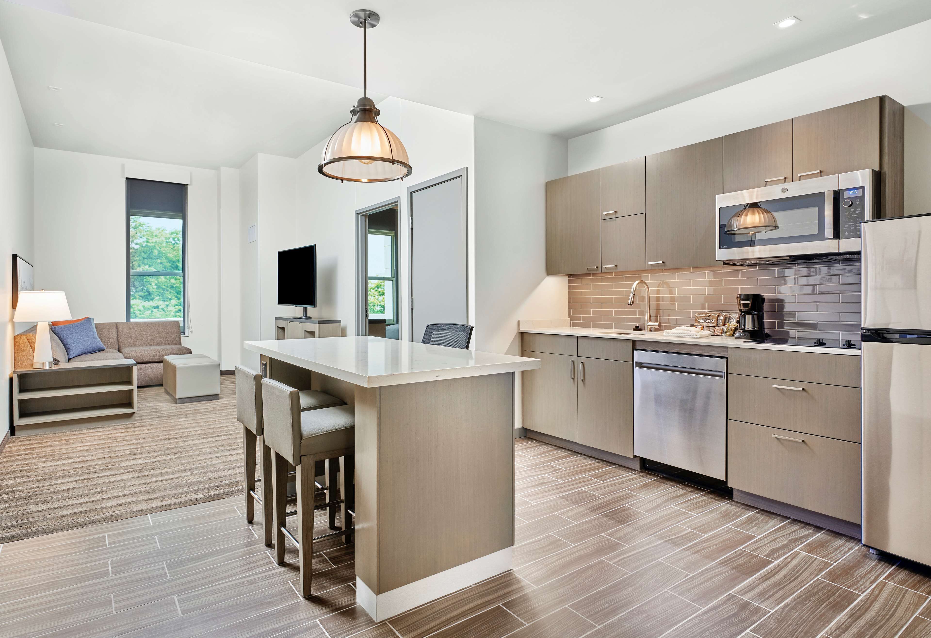 A modern kitchen with a central island, built-in appliances, and a dining area with a sofa and chairs.
