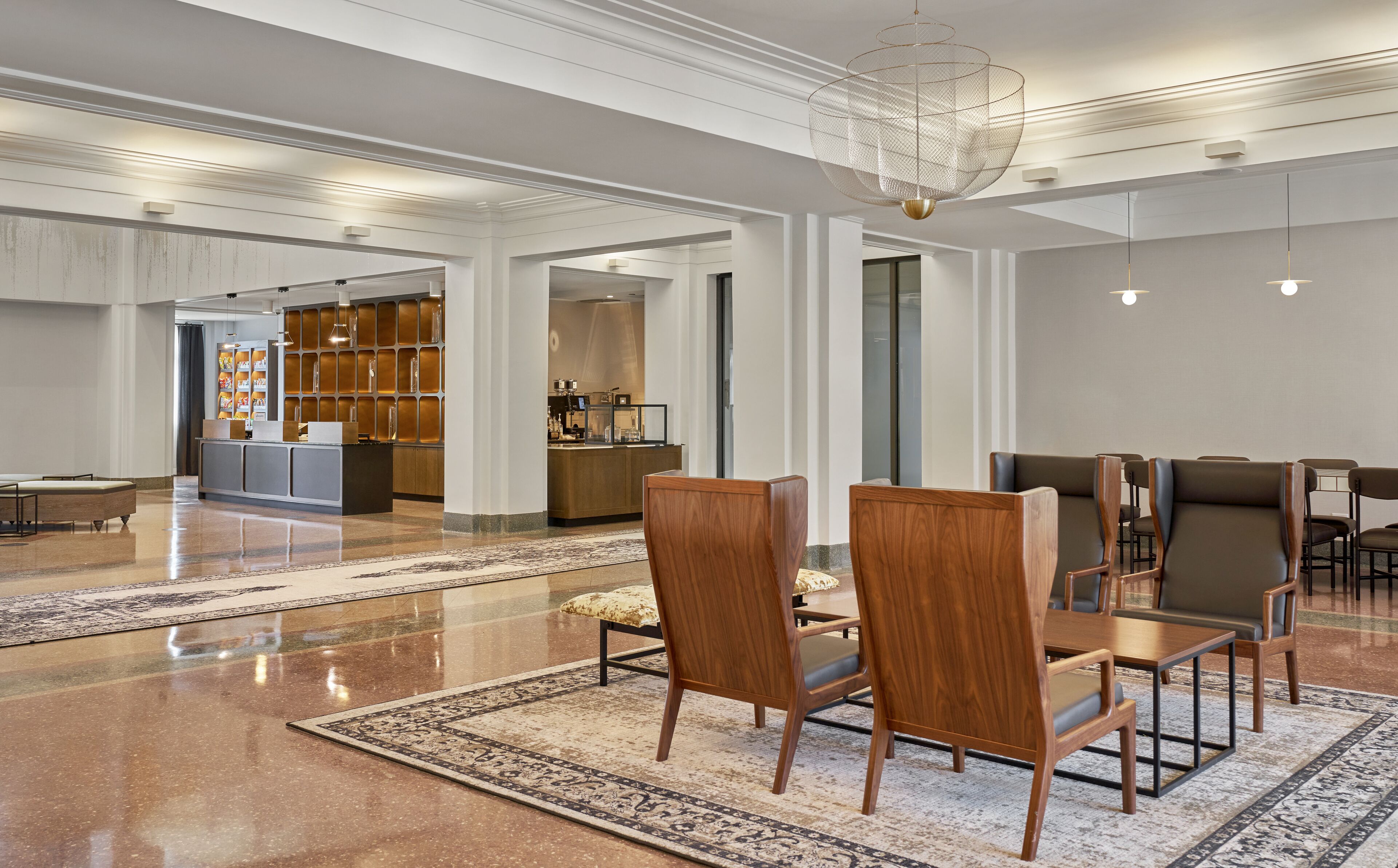 Eine großzügige Lobby mit Empfangstresen, Sitzgelegenheiten und einer modernen Chandelier.