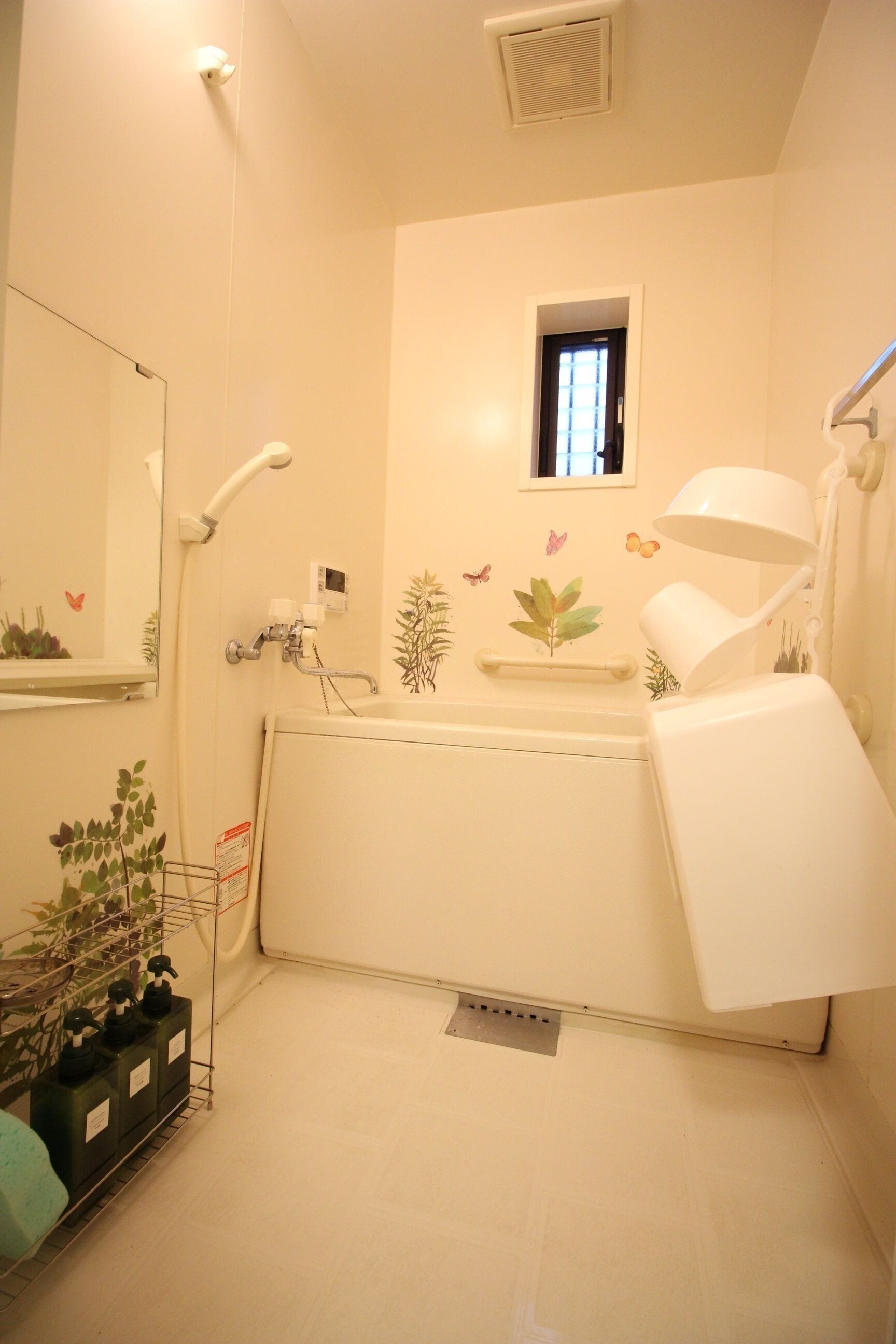 Casa de banho com lavatório, espelho, porta-toalhas e chuveiro.