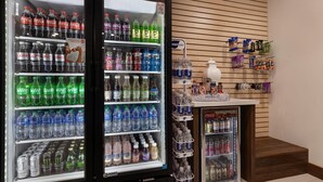 Un espace de vente proposant des distributeurs automatiques de Coca-Cola et de Sprite, un distributeur d’eau et un présentoir de collations.