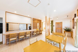 A modern dining area with wooden furniture and a long counter.