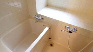 Un baño con bañera y ducha.