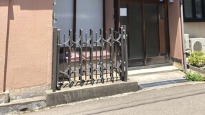 A two-story residential building with a metal gate, a small porch, and a visible number '1218' on the door. - Kanazawa-Hachitabi Hashiba (Kanazawa)
