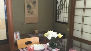 A dining table with a vase of flowers, plates, and cups. - Kanazawa-Hachitabi Hashiba (Kanazawa)