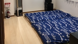 A bedroom with a bed, a TV, a mirror, and a fire extinguisher. - Kanazawa-Hachitabi Konjiki (Kanazawa)
