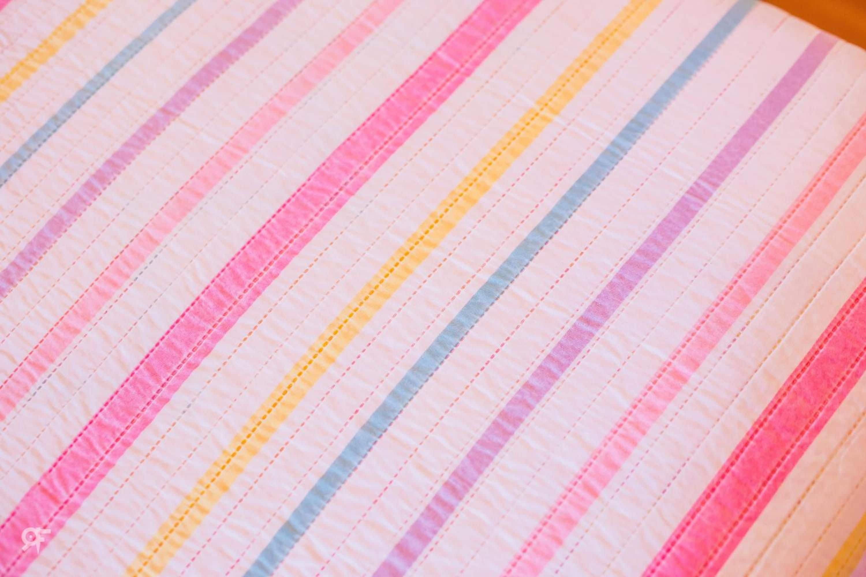Primer plano de una tela a rayas con colores alternados.