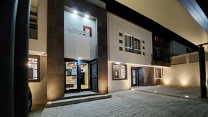 L’entrée d’un hôtel au design moderne, avec une porte en verre et une enseigne au-dessus.