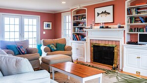 Una sala de estar con chimenea, estanterías y televisor.