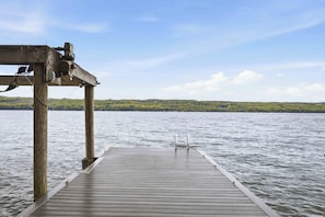 A wooden dock extending into calm water with a clear sky above.
