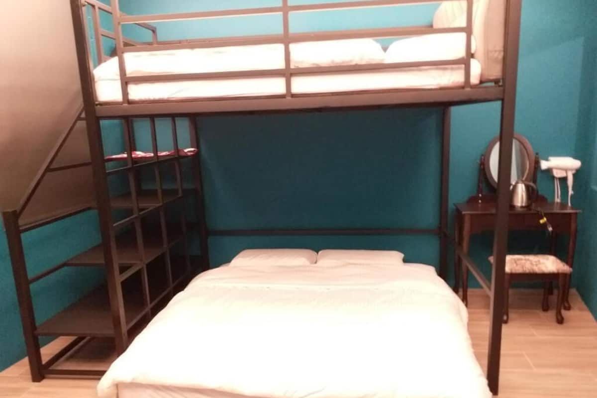 A bunk bed with a wooden frame, a small desk with a chair, and a mirror.