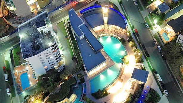 A high-rise hotel with a rooftop pool, multiple swimming areas, and a glass atrium. - Holidays Gold Coast (Surfers Paradise)