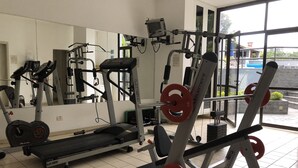 A gym with various exercise equipment, including a treadmill, weight machines, and a bench press. - Cozy and Cozy Apartment Portal do Morumbi (Vila Suzana)