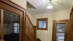 A wooden staircase with a patterned rug, a ceiling fan, and a view of the outside through a window. - Exceptional new listing Decorah Craftsman Bungalow (Decorah)