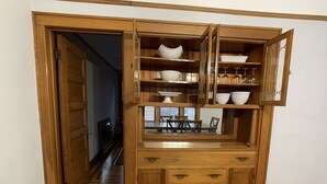 A wooden cabinet with multiple shelves and drawers, containing various kitchenware and a small dining table setup. - Exceptional new listing Decorah Craftsman Bungalow (Decorah)