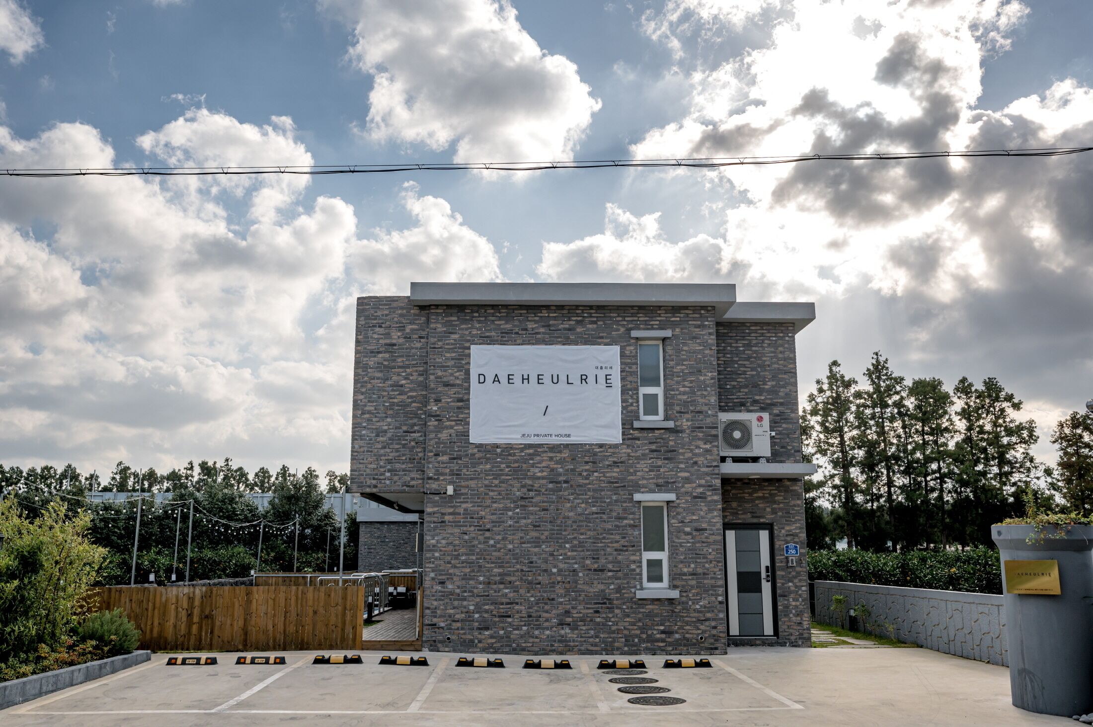 A modern building with a sign reading "DAHEULRIE PRIVATE HOUSE".
