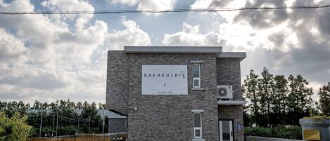 A modern building with a sign reading "DAHEULRIE PRIVATE HOUSE".