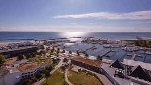 A marina with boats docked, a pier extending into the water, and buildings with green roofs. - Holiday home with WIFI and terrace (Damp)