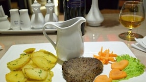 A plate with food, a white pitcher, and a glass of wine on a table. - D&C Hotel Danang (Da Nang Municipality)