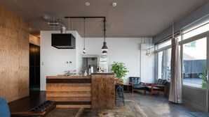 Una cocina moderna con una isla central, detalles de madera e iluminación colgante.
