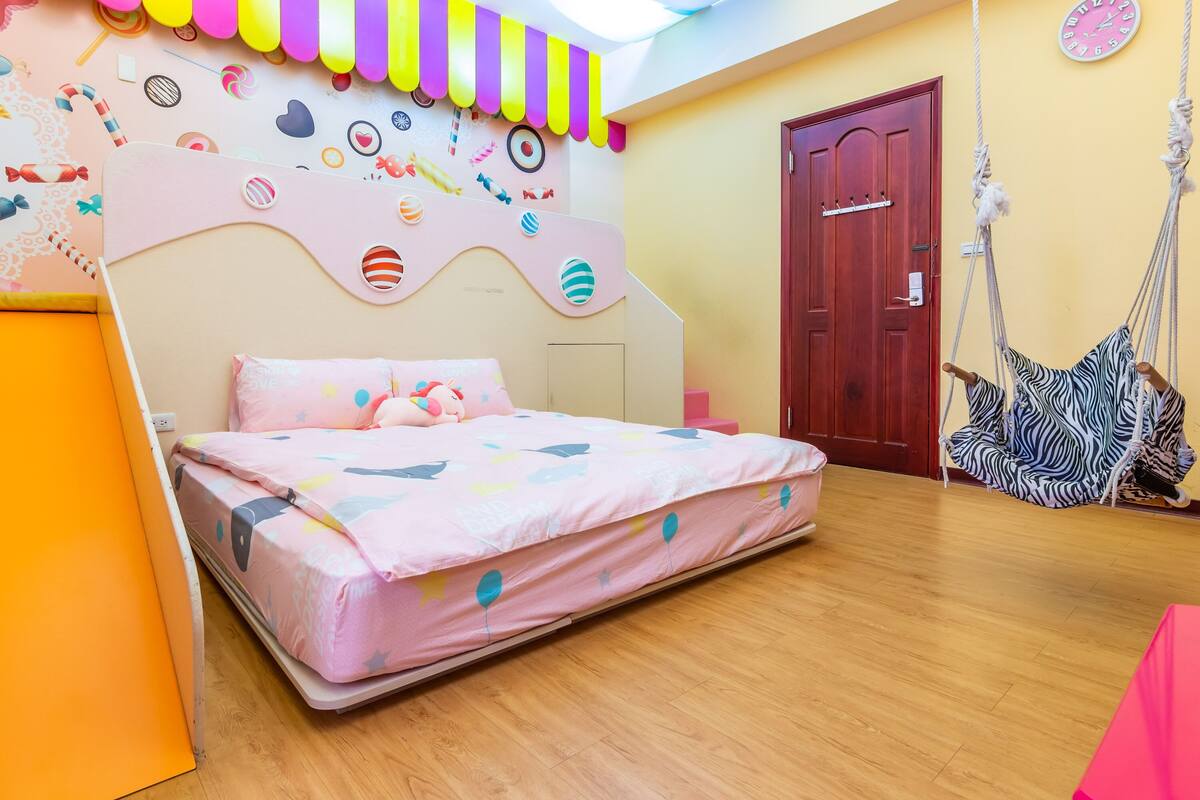 Un dormitorio con cama, una silla colgante y una puerta.