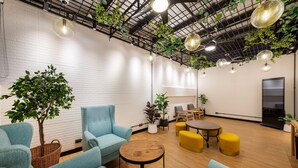 Un espace de détente moderne, doté de sièges, d’une table basse et de plantes suspendues.