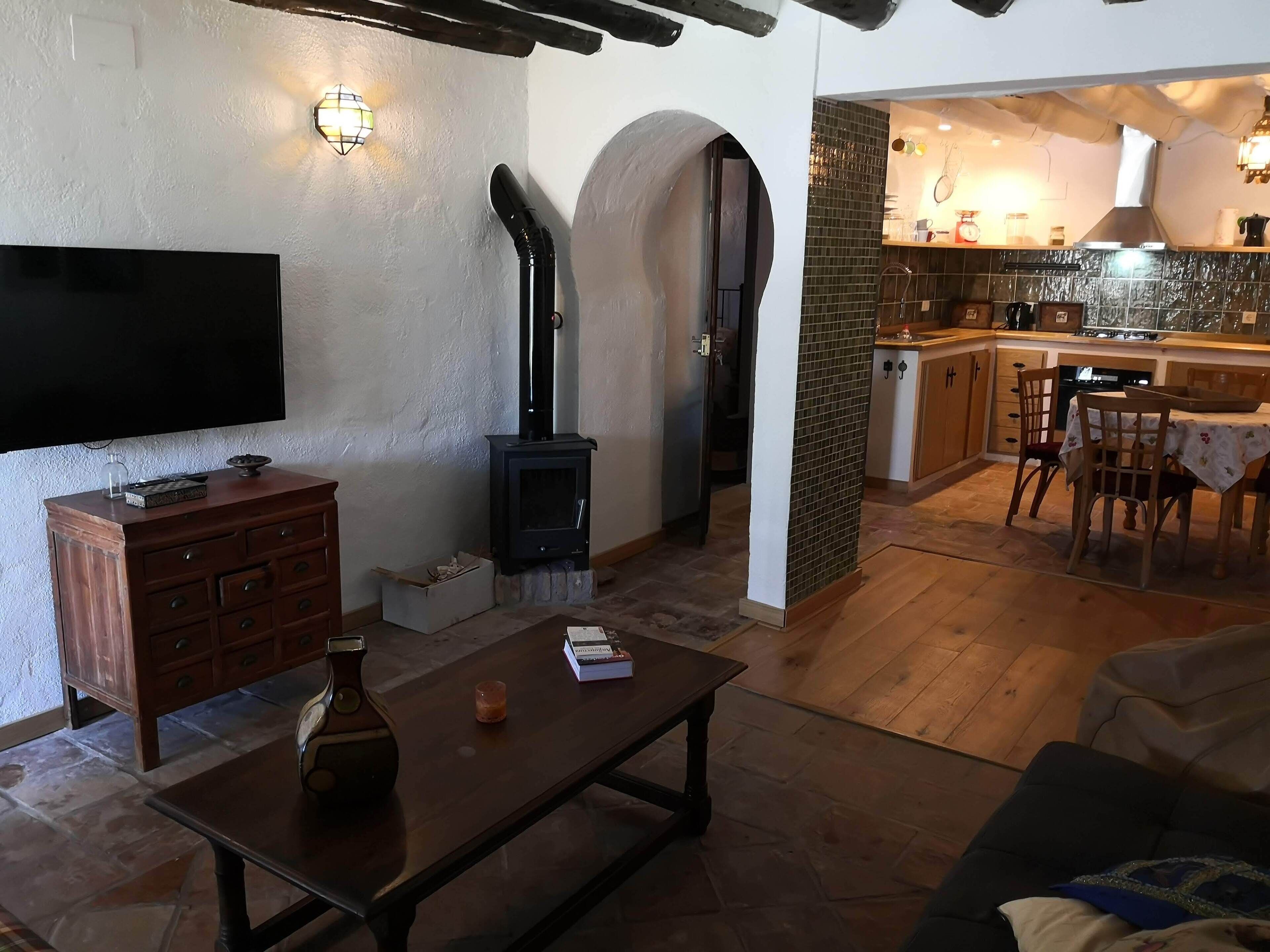 A cozy living room with a fireplace, a television, and a dining area with a table and chairs.