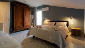 Ein Schlafzimmer mit Bett, Kleiderschrank, Nachttisch und Spiegel.