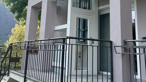 Ein modernes Gebäude mit Glastür und einer Metallrelinge im Vordergrund.