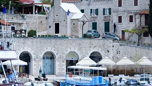 Un edificio de piedra con fachada de estilo tradicional, una torre de campanas y un asta de bandera.