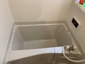 A white bathtub with a handheld showerhead and a control panel. - GH One More Heart Kyoto Station South 4 (Kyoto)