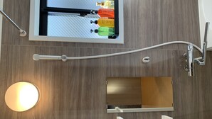 A bathroom with a wooden wall, a mirror, a sink, a toilet, and a shower area. - GH One More Heart Kyoto Station South 6 (Kyoto)