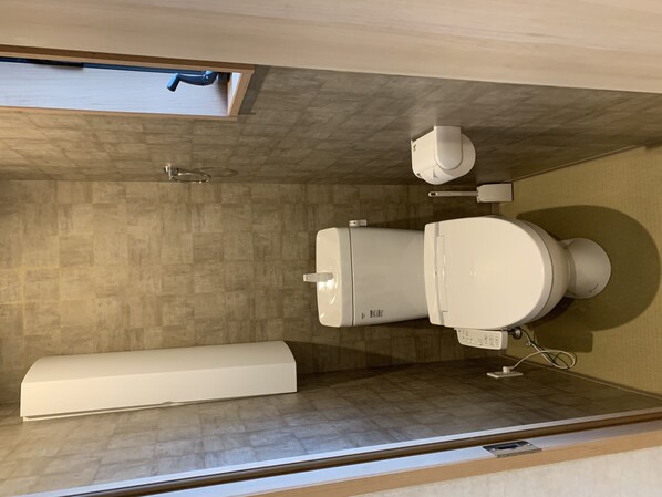 Un baño moderno con inodoro, bidé y un espejo grande.