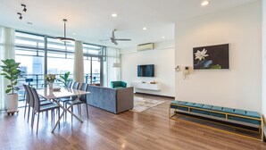 A modern living room with a dining area, large windows, and a city view. - Saigon Skyline Suite in Central District 1 (Ho Chi Minh City)