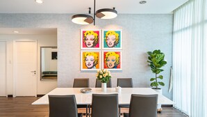 A dining area with a white table, black chairs, and a potted plant. - Saigon Skyline Suite in Central District 1 (Ho Chi Minh City)