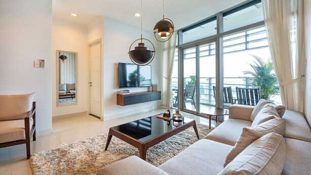 A modern living room with a sofa, coffee table, and TV. - Sai Gon Finest - Panorama Suite in Central D1 (Ho Chi Minh City)