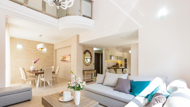 A modern living room with a sofa, coffee table, and dining area. - Peris Villa (Chania)